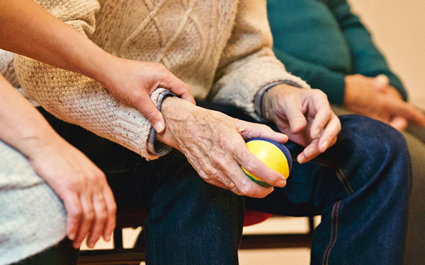 mano de persona mayor con pelota de deporte